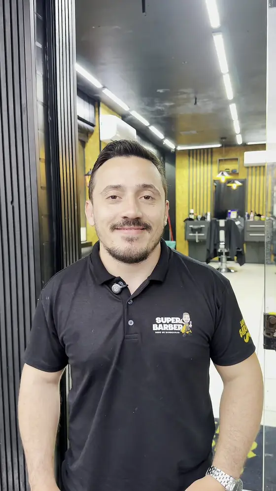 Barbeiro sorrindo na entrada do salão